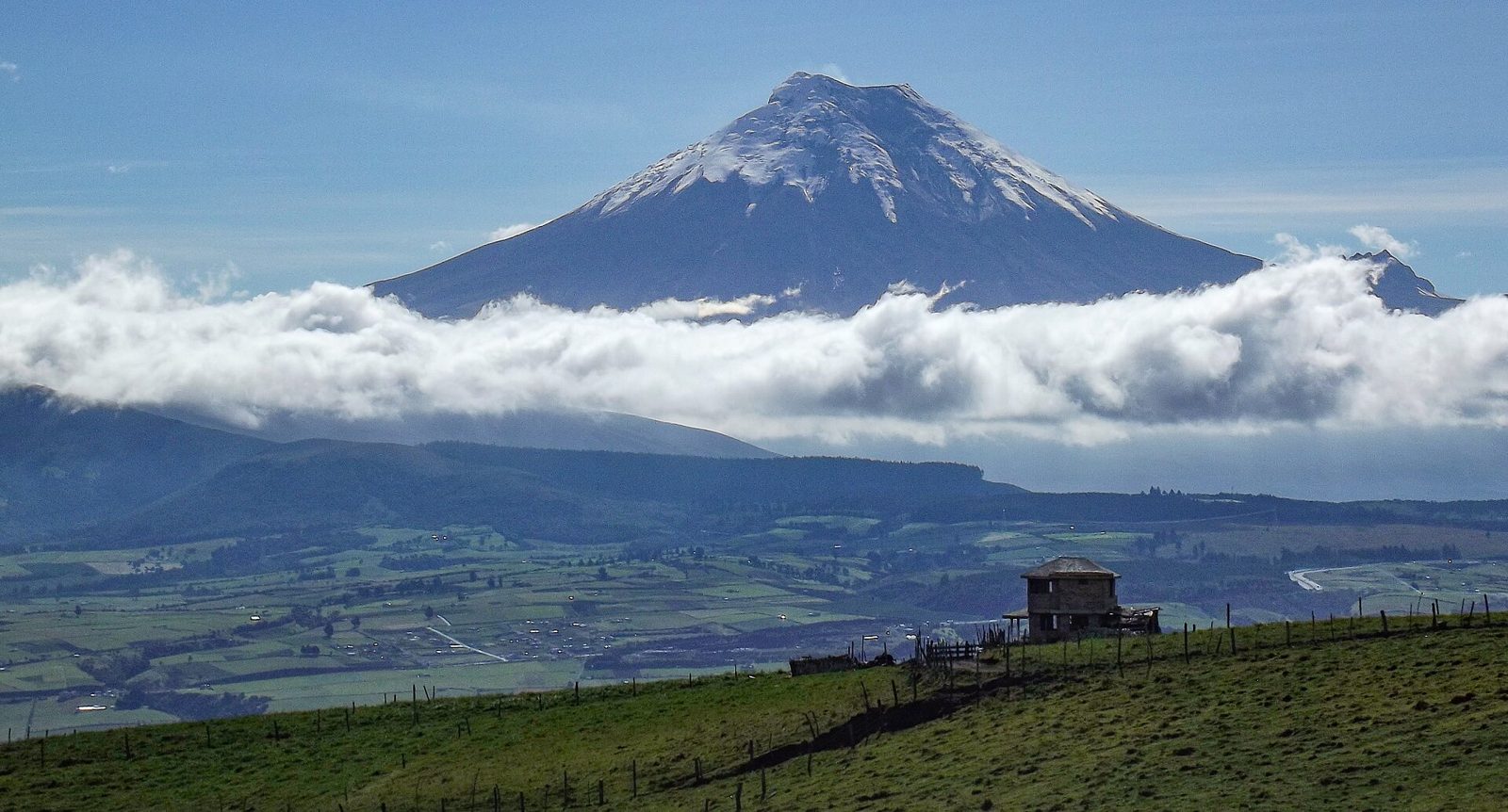 農地の向こうにそびえる円錐形の火山（コトパクシ）