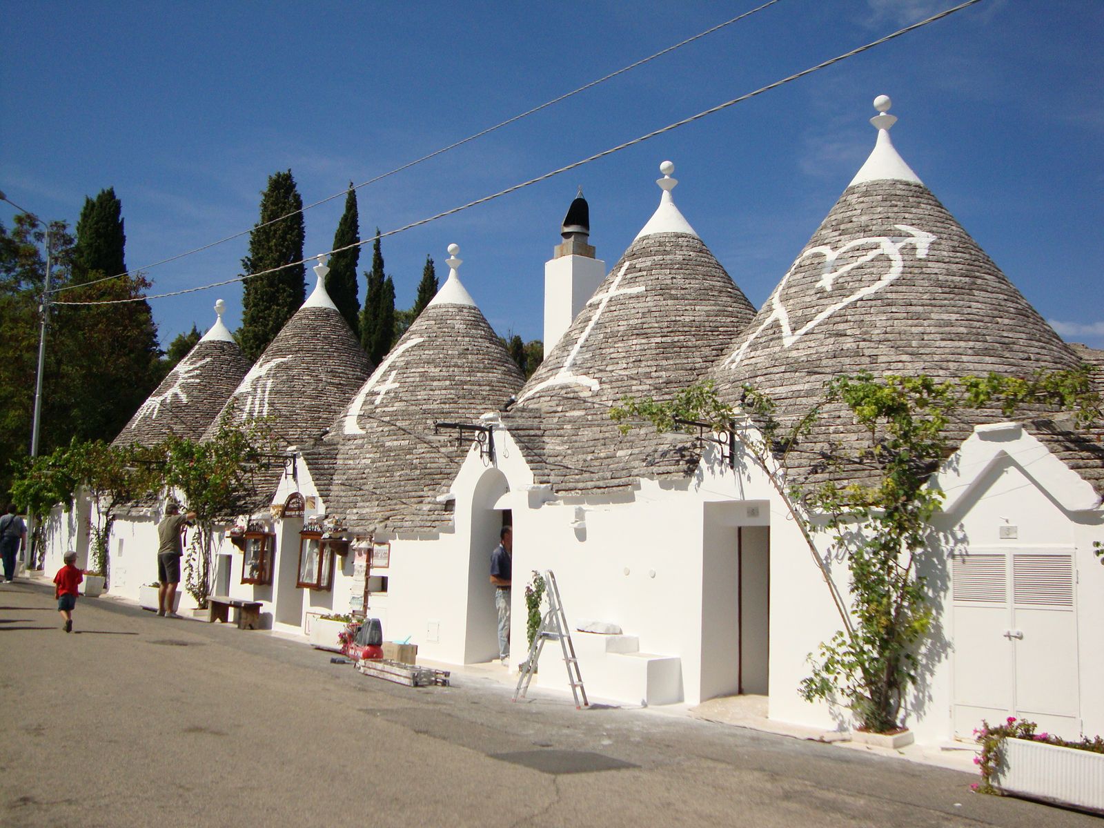 石積みの円錐屋根を持つ白いトゥルッロの並ぶ通り(Puglia州Alberobello)